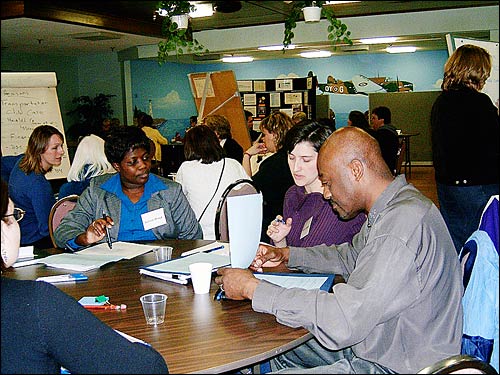 photo of Eunice Abaga (dept of Health), Karen Gatien (dept of Ed) and Allister Johnson discussing project